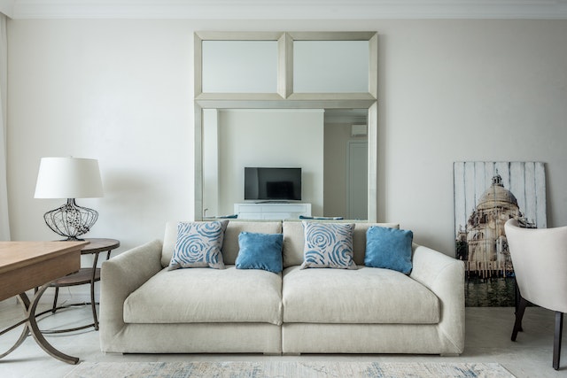 living room with cream coloured couch and blue throw pillows)